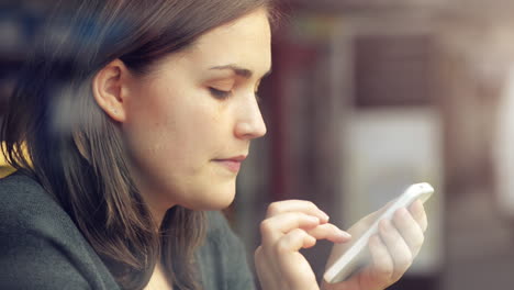 woman using mobile phone touchscreen in cafe