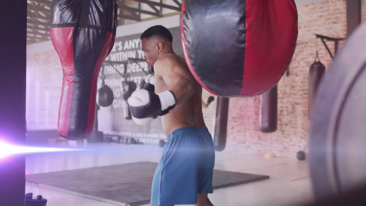 Male boxer stepping in from high guard, throwing jabs and crosses into heavy bags, training power