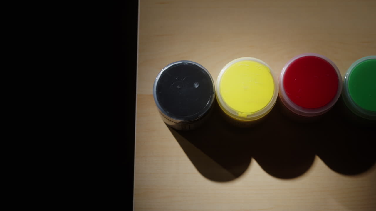 Colorful Paint Pots on Wooden Surface