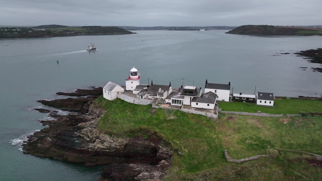 로치스 포인트 등대 (roches point lighthouse, east cork, ireland) 의 드론 영상, 멀리에서 배, 크로스헤이븐, 코브를 보여준다.