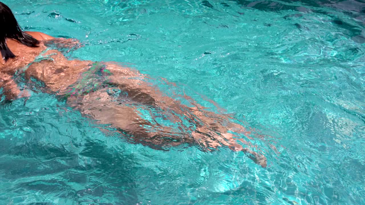 여자 가 수영장 에 수영 하고 있다