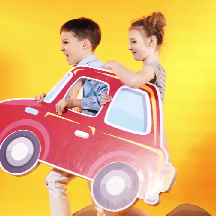 Gruppo eterogeneo di bambini che saltano e si divertono. Sfondo giallo in studio. Video quadrato