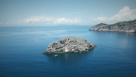 Gran-Roca-En-El-Mar-Con-Un-Pequeño-Bote-De-Goma-Argentarola