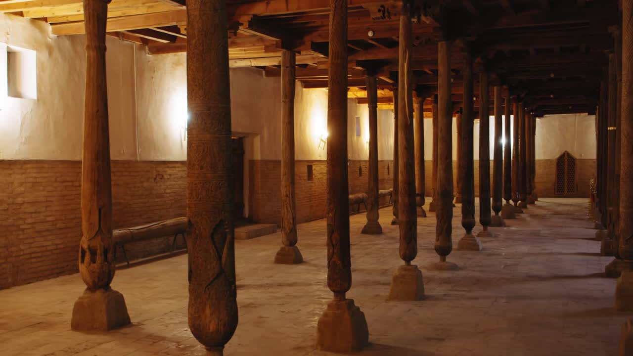 Ancient Mosque Interior with Wooden Pillars and Intricate Carvings