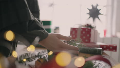 las manos de una joven mueven un regalo empaquetado sobre la mesa y se lo pasan al comprador. para entregar un regalo envuelto ya hecho, la niña toma un regalo en sus manos en la tienda