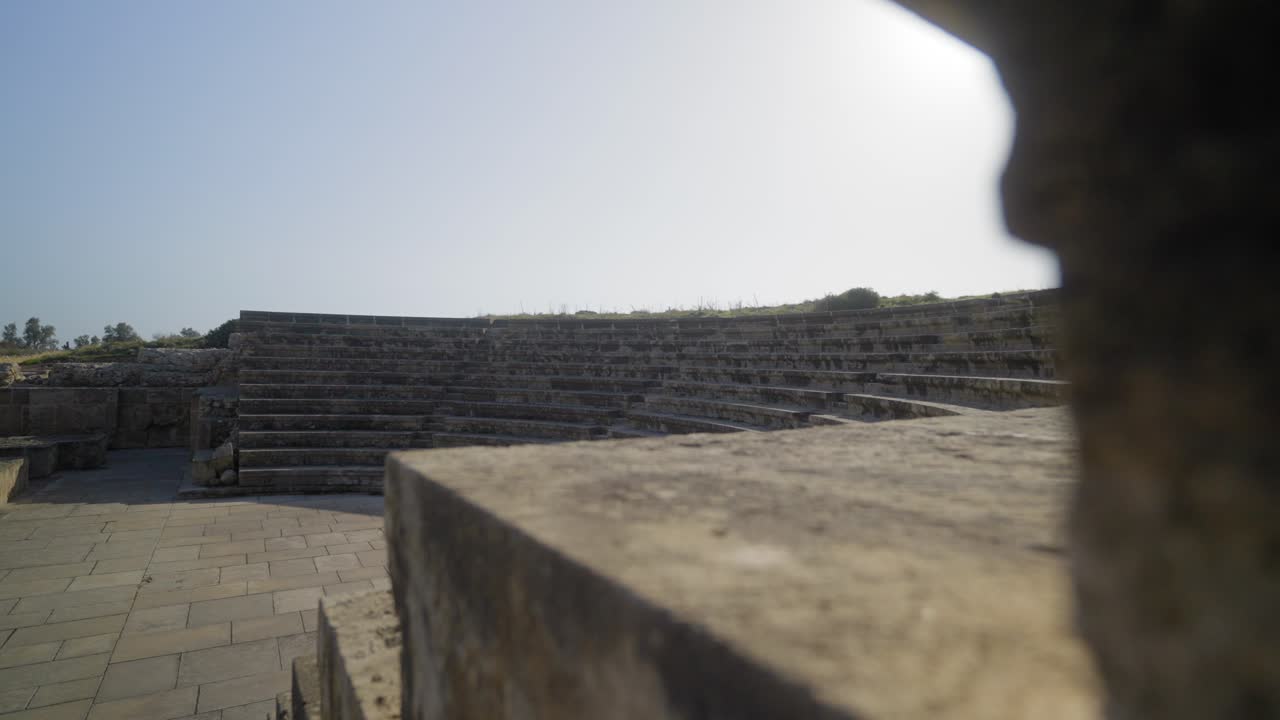 Rivelazione al rallentatore di un antico teatro Odeon romano con il sole che splende sulla gradinata in pietra