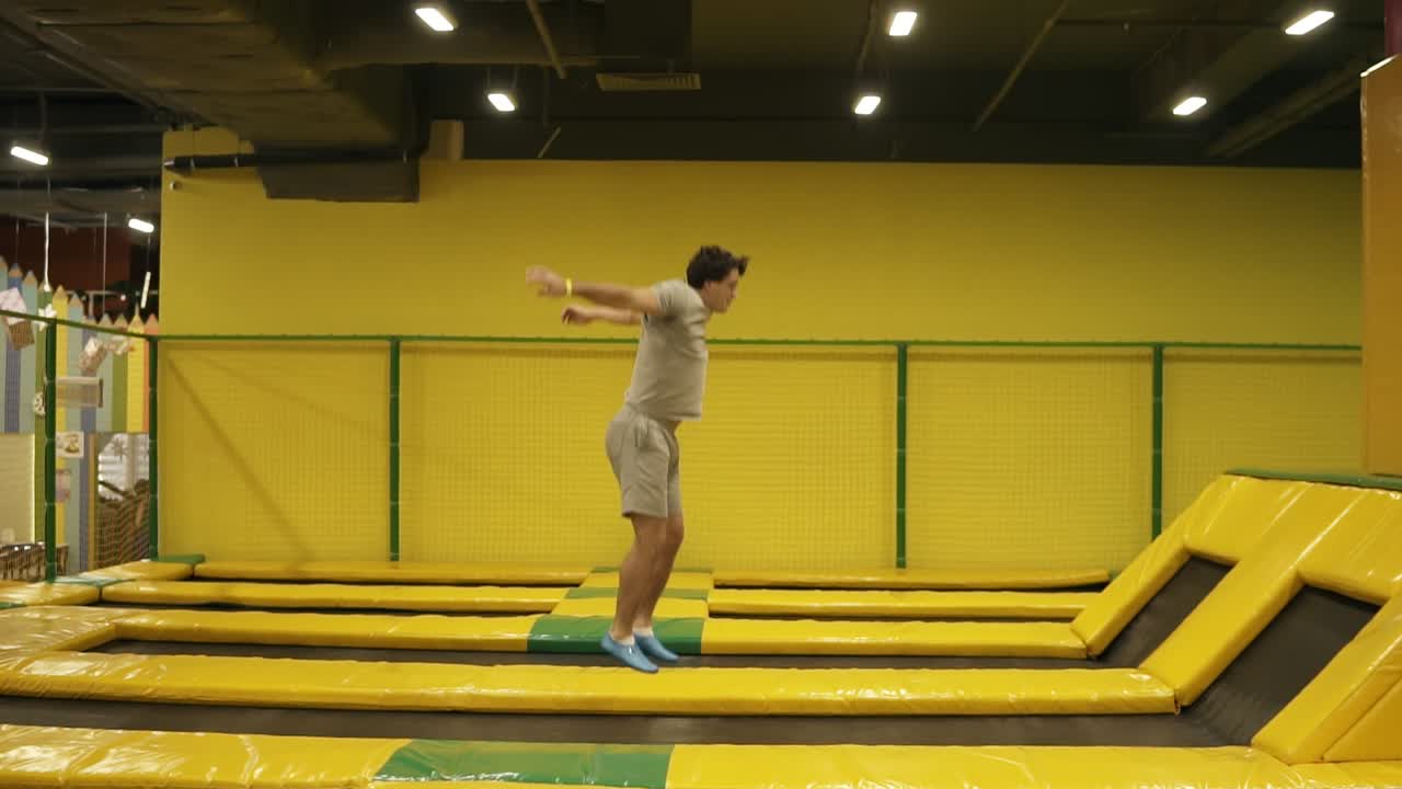un joven atlético que disfruta saltando en el trampolín.