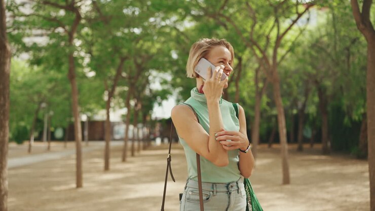 Donna che si gode una telefonata in un parco