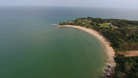 Aerial-view-of-the-African-coastline-of-Mermaids-Bay-in-San-Pedro-Ivory-Coast-showing-trees-and-residences