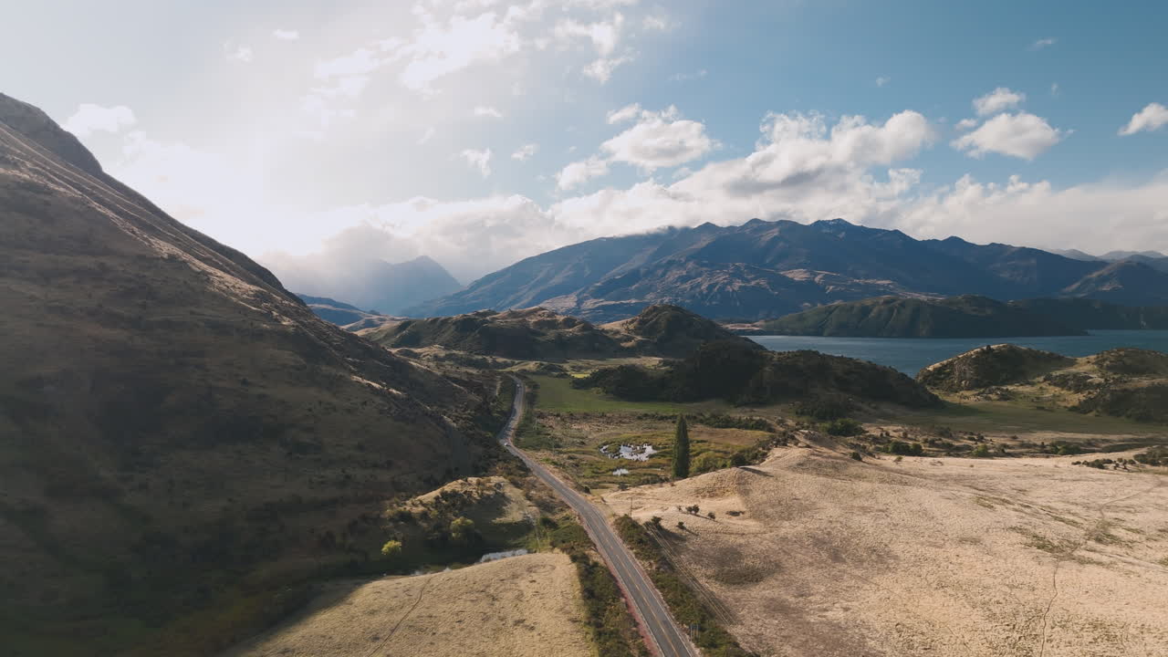 Aerial View of a Scenic Road Through Mountains and Valley with Lake