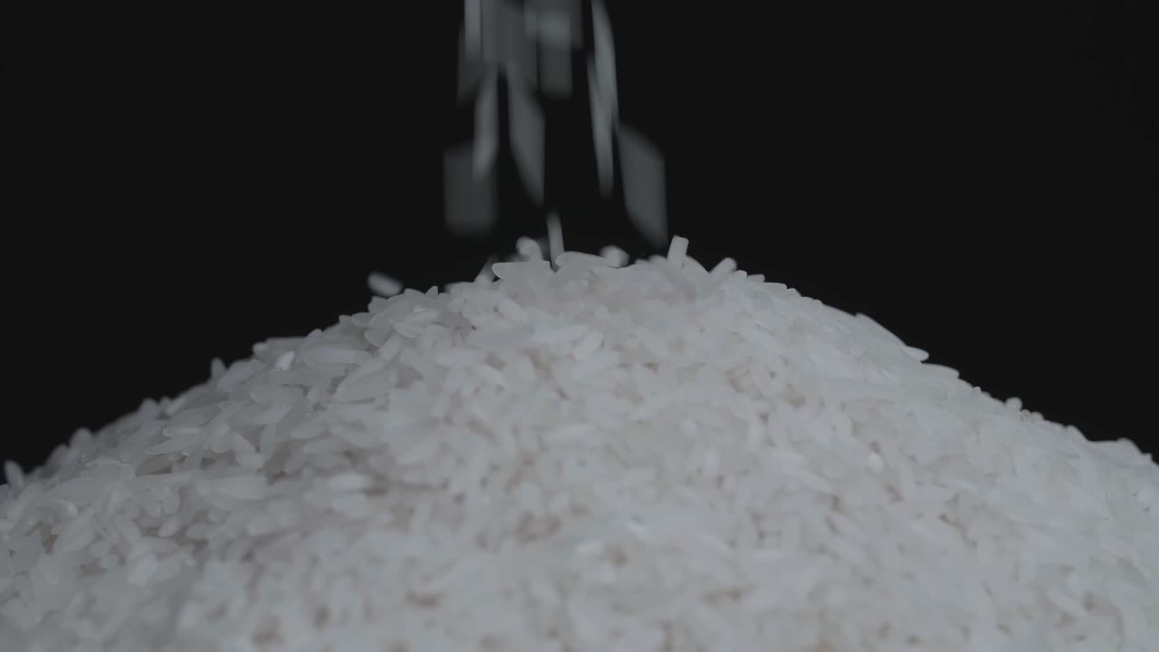Pile Of White Rice Grain Pouring And Rotating, On A Black Background