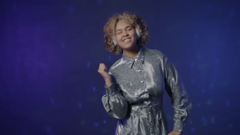 woman dancing to music in a silver dress