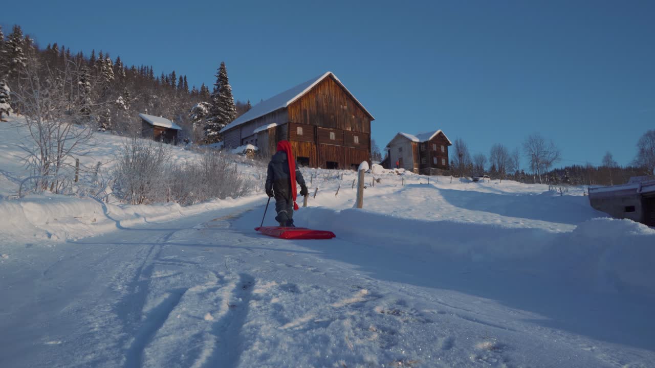 Un bambino tira una slitta in un giorno di Natale d'inverno in Norvegia.