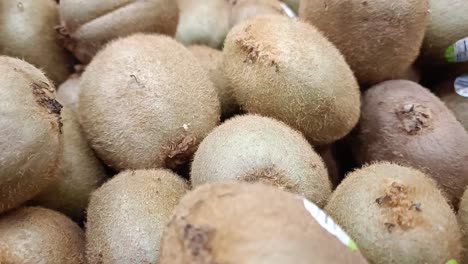 des kiwis verts et mûrs sur une étagère d'un supermarché