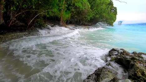 huge waves splashes into rocky shoreline