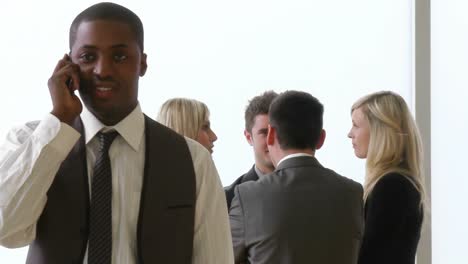 ethnic businessman on phone with his team in the background footage