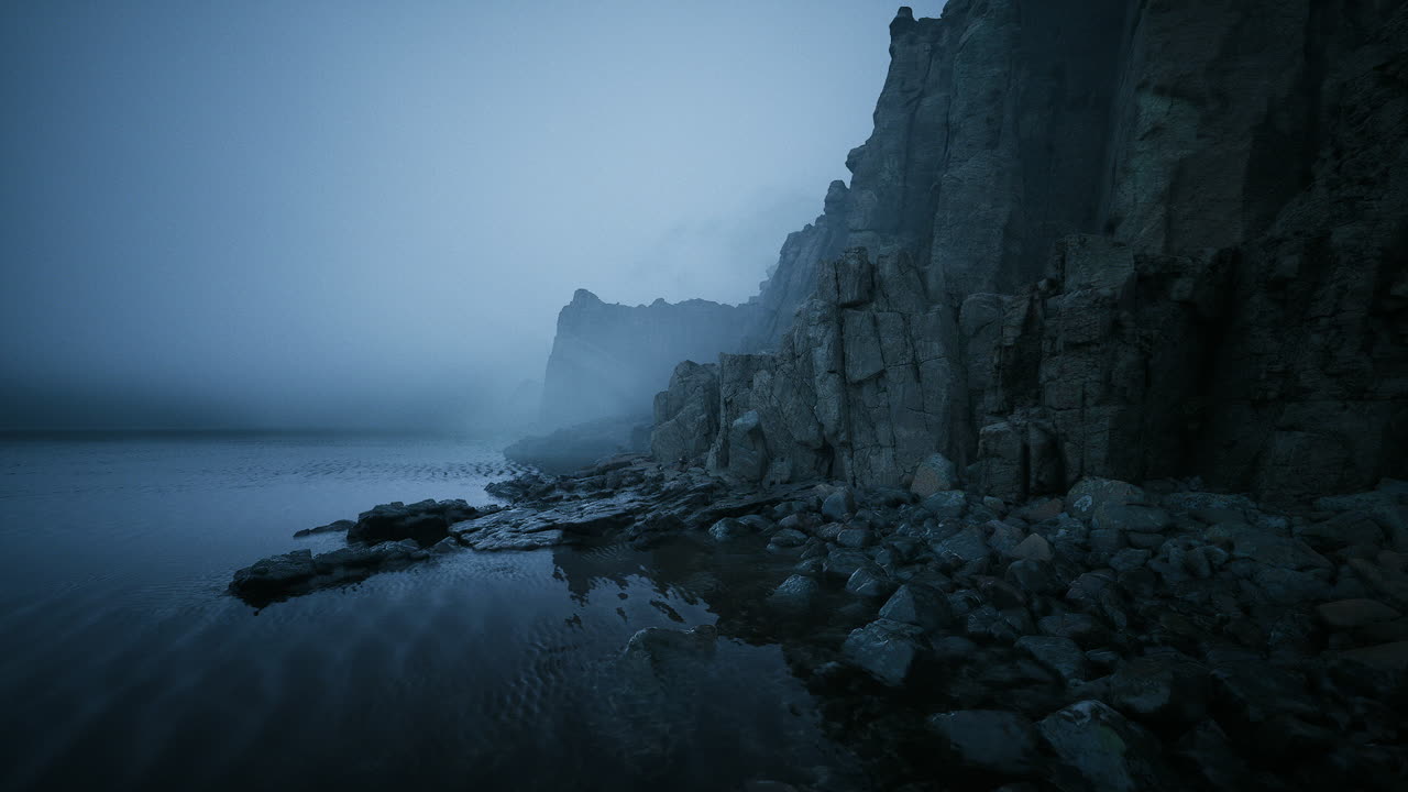 Misty coastline at twilight revealing rocky cliffs and serene waters