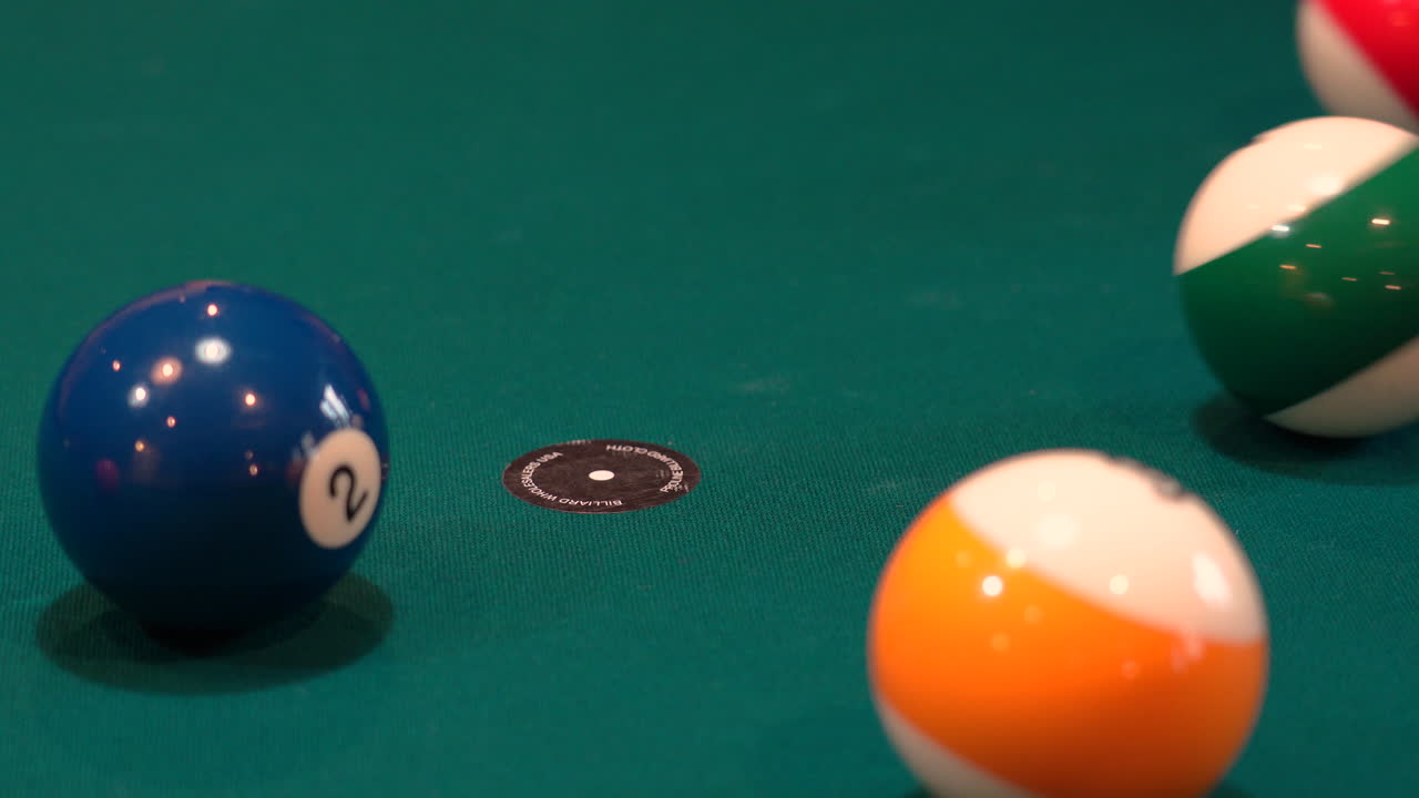 Person Racks 8 Ball Pool Triangle Closeup on the Spot then Rearranges Solid and Stripped Billiard Balls on Table with Green Felt or Cloth and Shakes Rack with Hands before Lifting Wooden Triangle