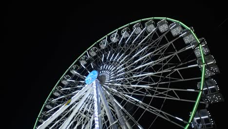 vista nocturna en una gran rueda gigante con una hermosa iluminación. rueda gigante de invierno girando en un parque de atracciones. video de resolución 4k