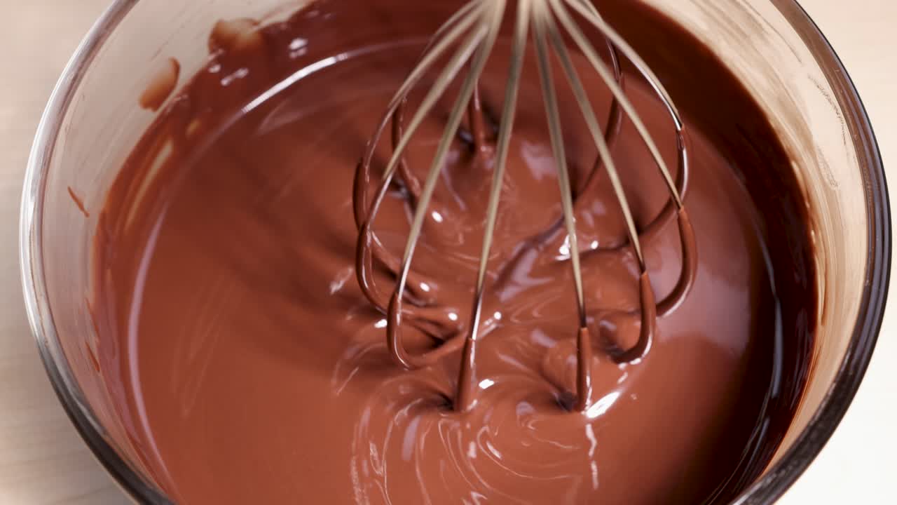 batir y agitar el chocolate derretido en un cuenco de vidrio hasta que esté liso