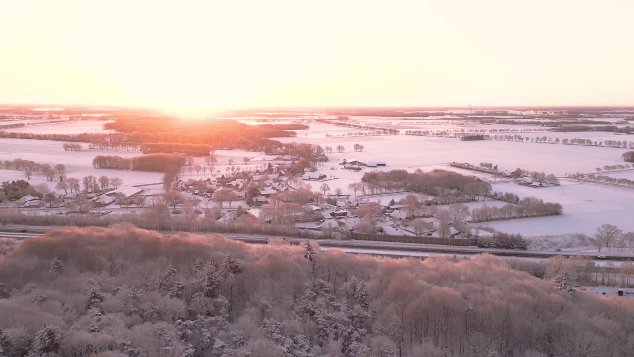 눈 인 네덜란드 마을 위의 겨울 해가 뜨는 모습