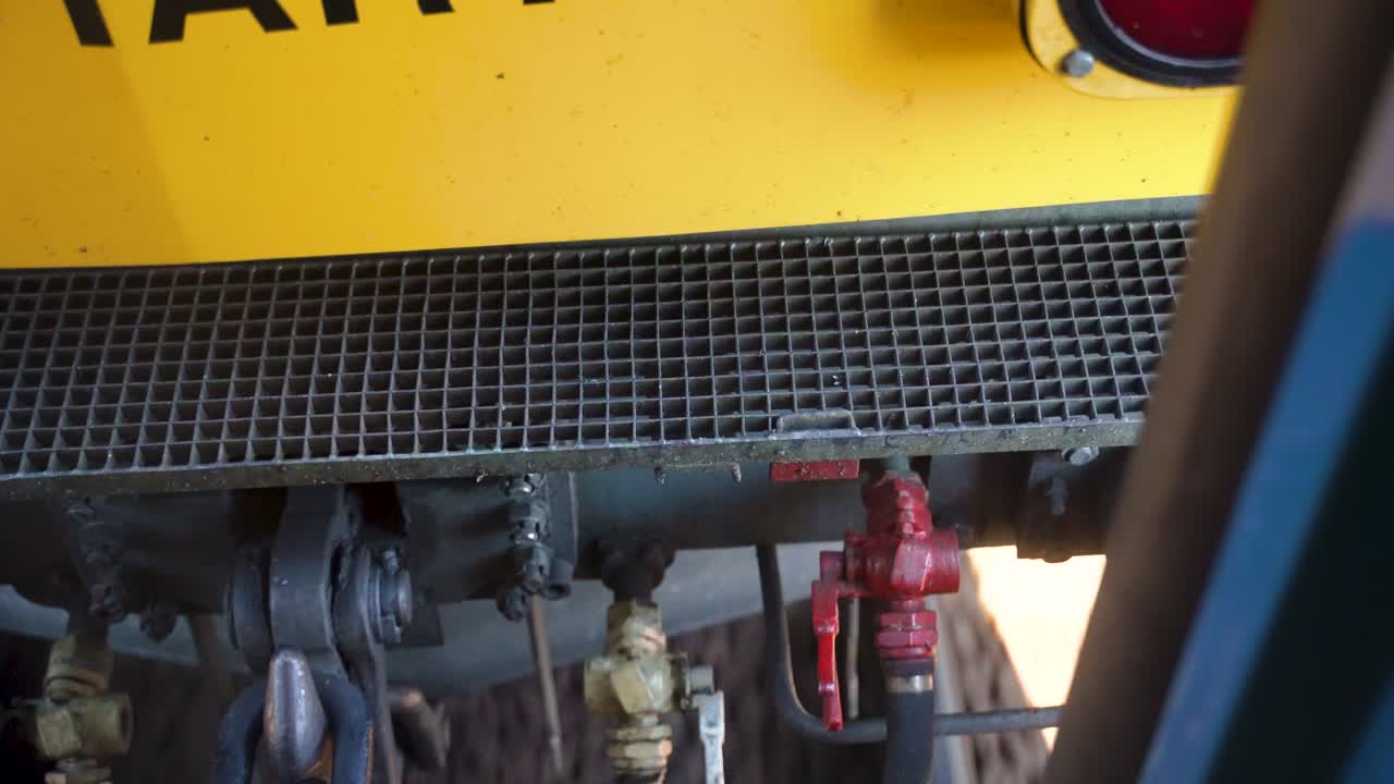 Looking down at two train coaches connected meanwhile slows down