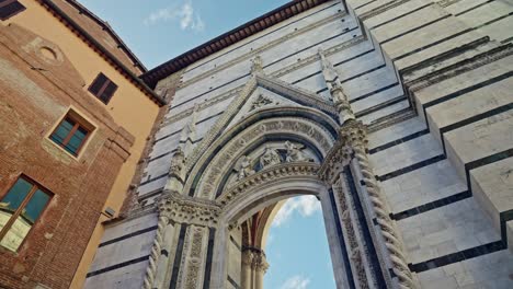 detail of the arch entrance to the medieval siena cathedral in siena, italy from the piazza s