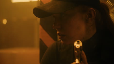 woman with gun in dark environment