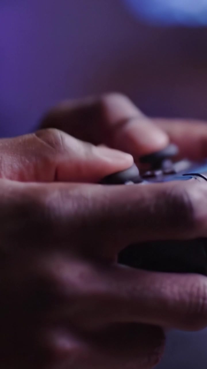 Intense Gaming Moments: Close-up Views of Hands Gripping a Controller with Focus and Determination in a Competitive Gaming Environment