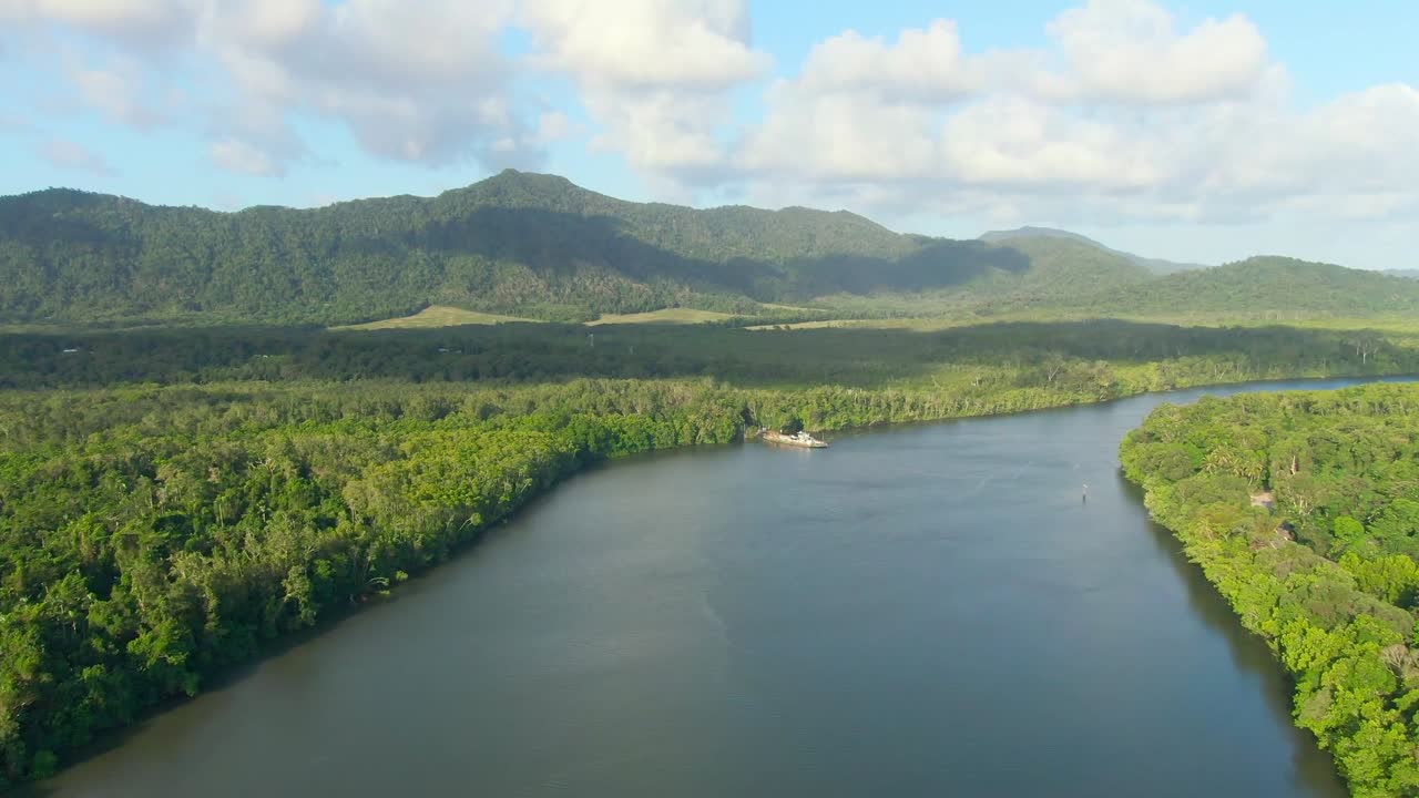 Push in along the Daintree River next to the Daintree Rainforest in Queensland, Australia. Croc infested water sit below as a ferry prepares to cross the river.