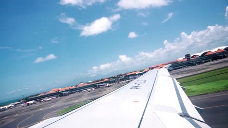 shot from taken from the window of the plane while it takes off during a sunny day near a beach