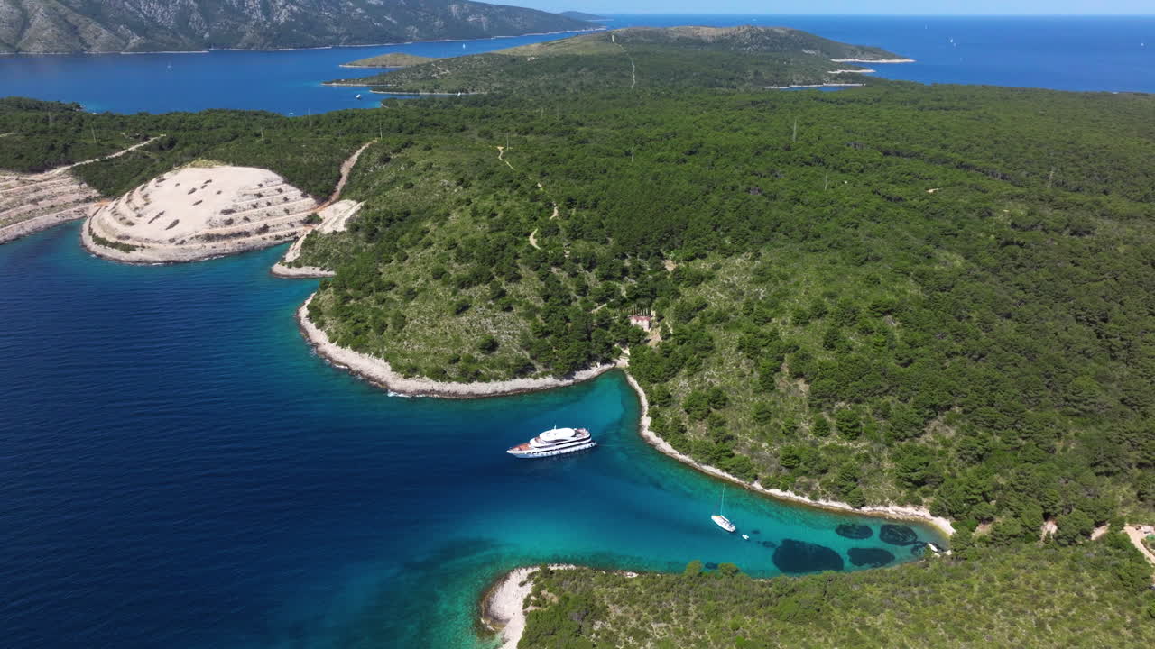 Pakleniöarna täckta av grön skog och yacht som flyter i lagunen i Kroatien. - flygfoto