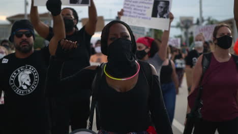 mixed ethnicity crowd protesting with raised fist at black lives matter protest, medium shot