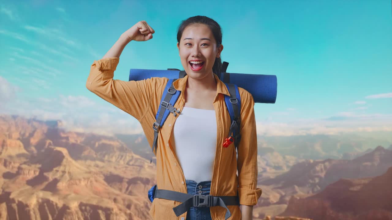 Asian Female Hiker With Mountaineering Backpack Smiling And Flexing Her Bicep While Traveling At The Top Of Mountain