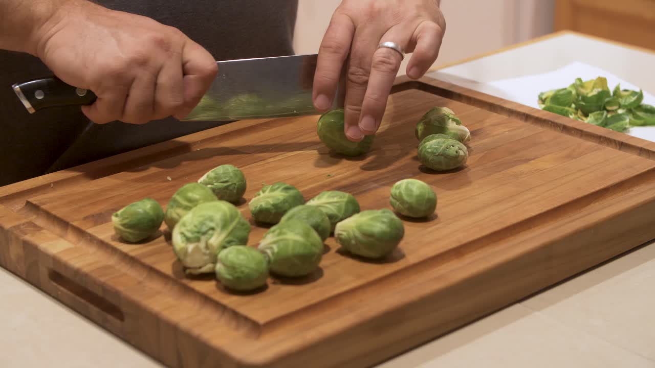 Cutting brussel sprouts on a wood cutting board