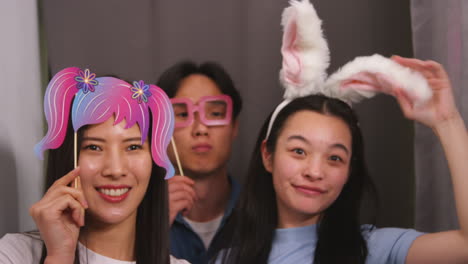 Group-Of-Young-Friends-Having-Fun-Posing-In-Photo-Booth-With-Props-Shot-In-Real-Time