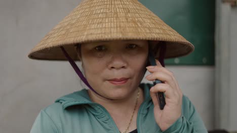 woman in straw hat talking on phone