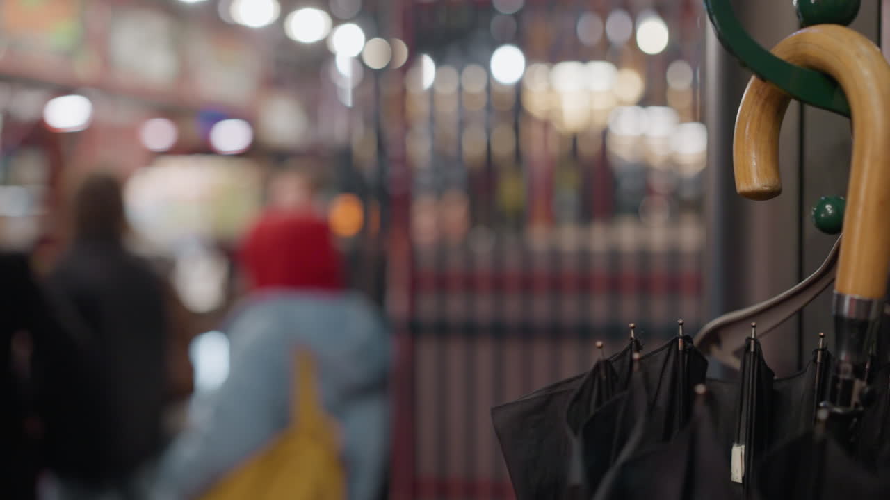 상점 의 초록색 스탠드 에 매달린 나무 손잡이 를 가진 검은색 우산 의 세트 의 가까운 시각