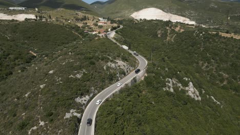 Vista-Aérea-De-Los-Automóviles-Que-Cruzan-La-Carretera-De-La-Isla-En-Zakynthos,-Mar-Jónico,-Grecia