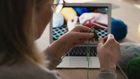 Nahaufnahme-Einer-Kaukasischen-Frau-Zu-Hause,-Die-Anhand-Eines-Video-Tutorials-Das-Stricken-Lernt