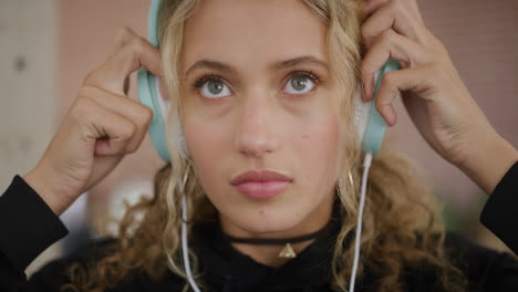 Retrato-De-Una-Hermosa-Joven-Rubia-Estudiante-Se-Pone-Auriculares-Relajándose-En-La-Universidad