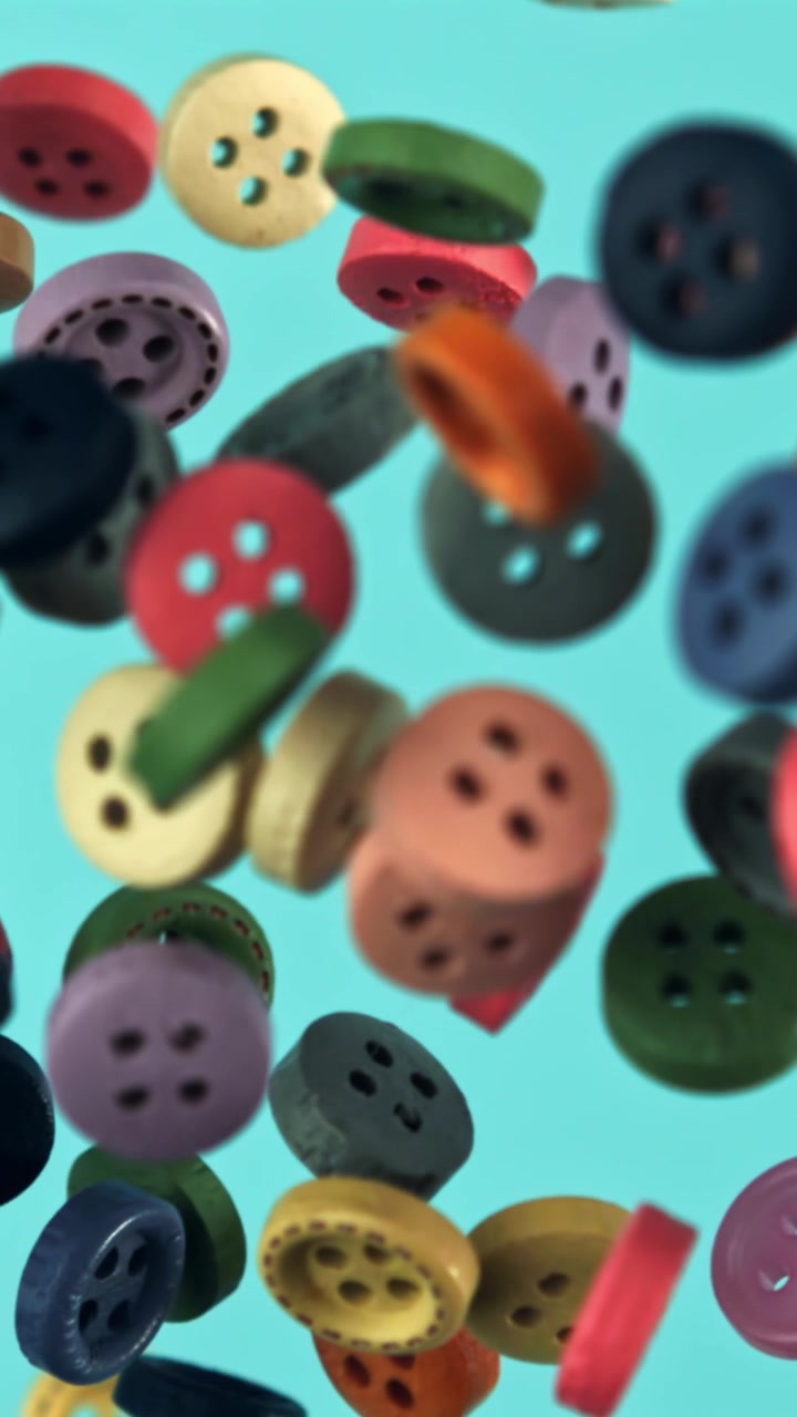 Leuchtend bunte Knöpfe fallen auf blauem Hintergrund