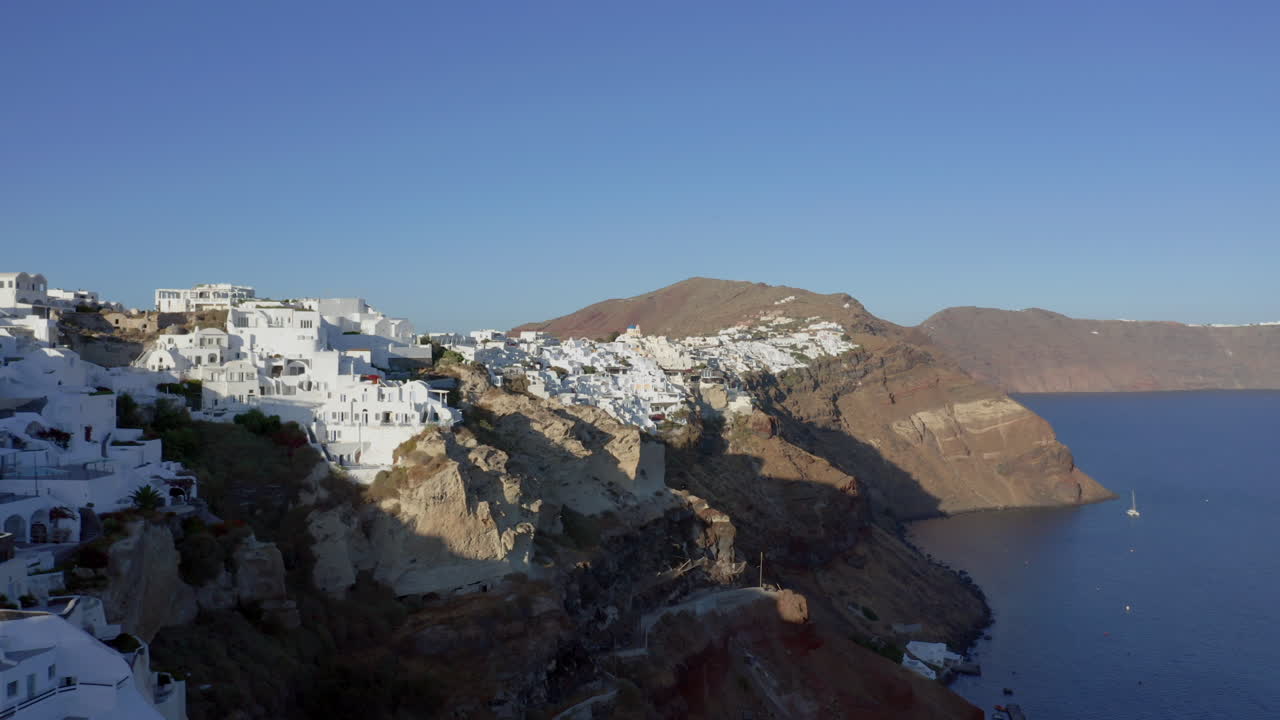 antena: volando sobre la ciudad de oia en santorini grecia durante la puesta de sol
