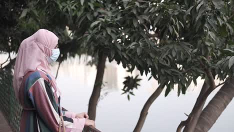 mujer en hijab usando una máscara, al aire libre