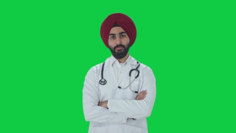 confident sikh indian doctor standing crossed hands green screen