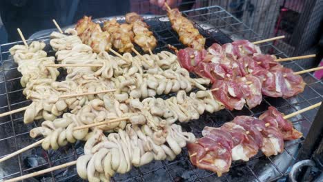 squid and chicken cooking on a barbeque in chinatown, bangkok, thailand