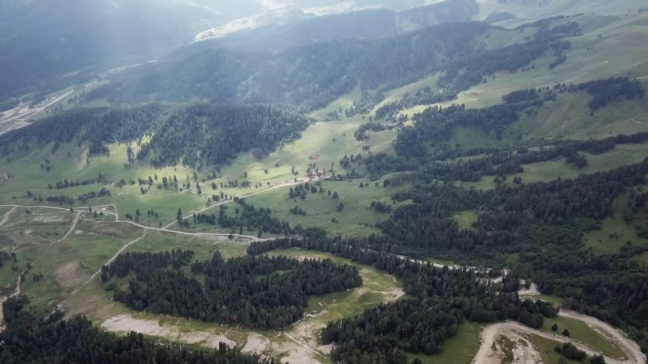 vista aérea de un valle montañoso con bosque y río
