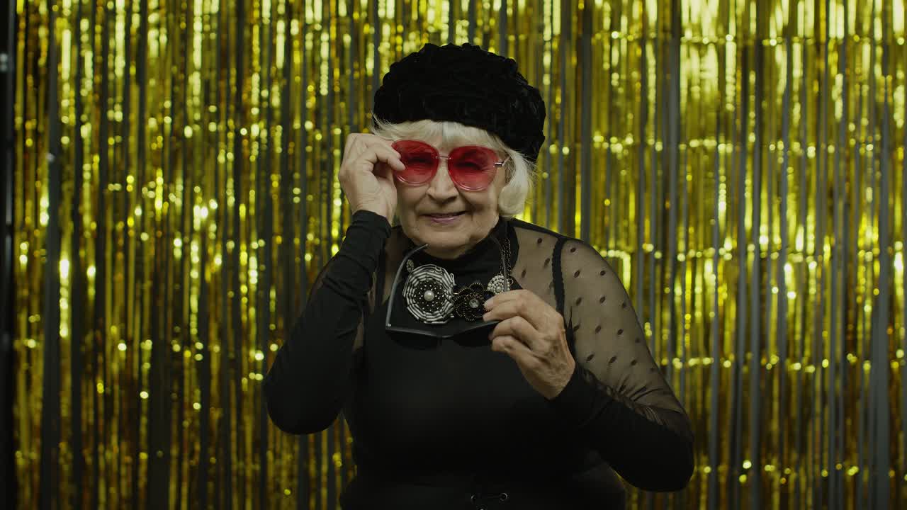 mujer mayor positiva con gafas de sol disfrutando, sonriendo, satisfecha de la vida, buen humor, éxito