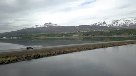 Conducción-De-Automóviles-En-La-Icónica-Carretera-De-Circunvalación-De-Islandia-Con-Montañas-Nevadas-En-Segundo-Plano