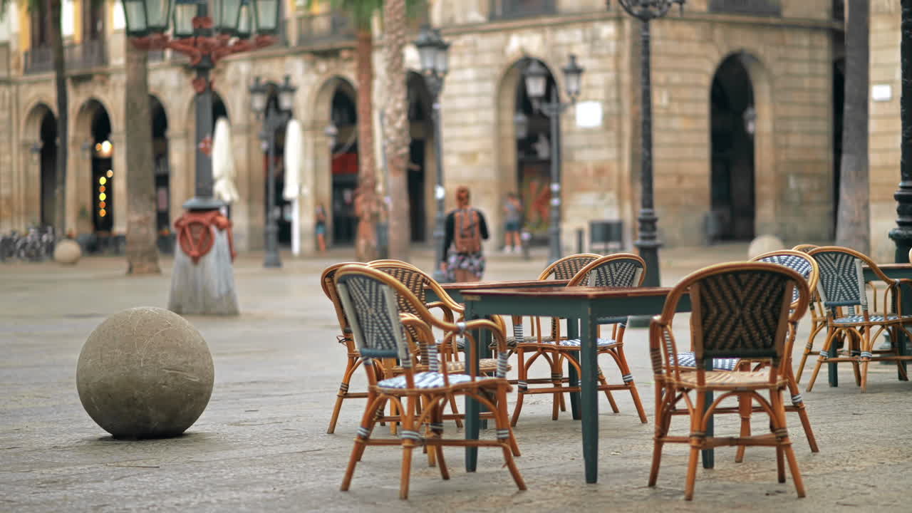 Square in Barcelona, Spain. Walking people, palms, buildings